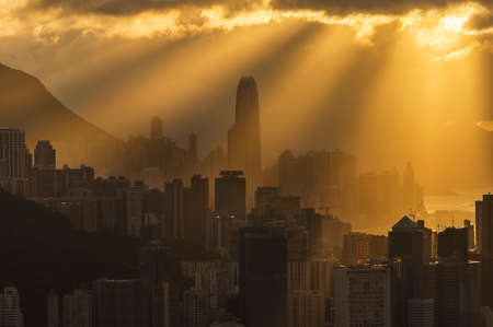 Silhouette of skyline of downtown of Hong Kong city with sun ray under sunsetの写真素材