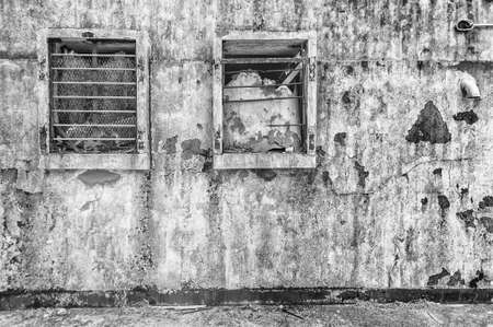 Broken window on wall of abandoned houseの写真素材