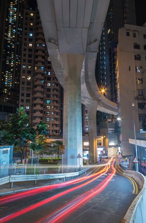 Elevated road through residential building in Hong Kong city at nightの写真素材