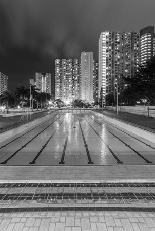 Swimming pool and high rise residential building in Hong Kong city at nightのeditorial素材