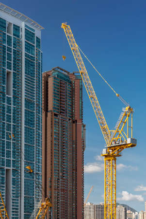 High rise residential building and crane in construction site in Hong Kong cityの写真素材