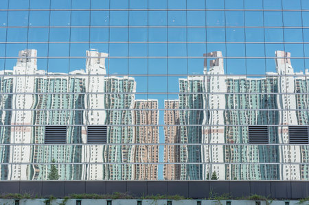 Reflection of high rise residential building of public estate on modern architecture in Hong Kong cityの写真素材