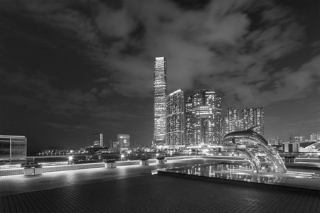 Hong Kong, China - October 15, 2022 : Night scenery of sculpture of dolphins jumping over pond and skyscraper in Tsim Sha Tsui district in Hong Kong cityのeditorial素材