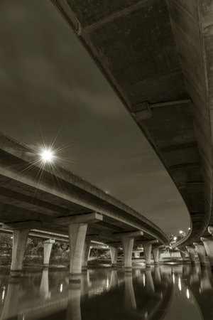 Underside of an elevated road across river at duskの写真素材