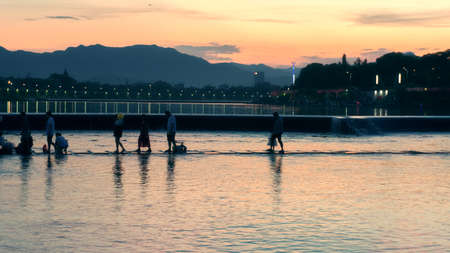 People walking on the river at dusk