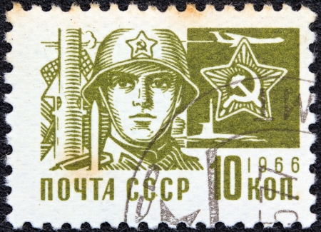 USSR - CIRCA 1966: A stamp printed in USSR from the "Society and Technology" issue shows a soldier and star emblem, circa 1966.のeditorial素材