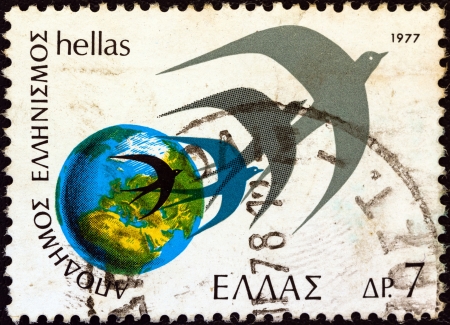 GREECE - CIRCA 1977: A stamp printed in Greece from the "Greeks Abroad" issue shows Globe and swallows, circa 1977.のeditorial素材