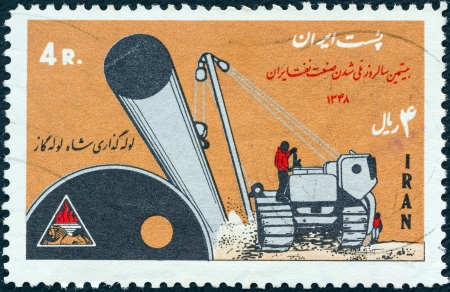 IRAN - CIRCA 1970: A stamp printed in Iran shows laying of gas pipe line and tractor, circa 1970. のeditorial素材