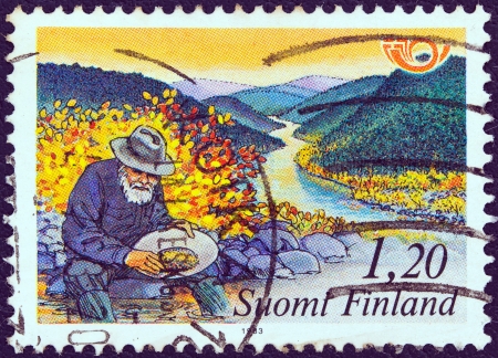 FINLAND - CIRCA 1983: A stamp printed in Finland from the "Nordic countries postal co-operation. Visit the north" issue shows a gold prospector, circa 1983. のeditorial素材