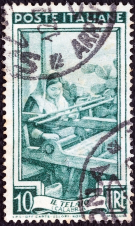 ITALY - CIRCA 1950: A stamp printed in Italy from the "Provincial Occupations" issue shows a Weaver (Calabria), circa 1950. のeditorial素材