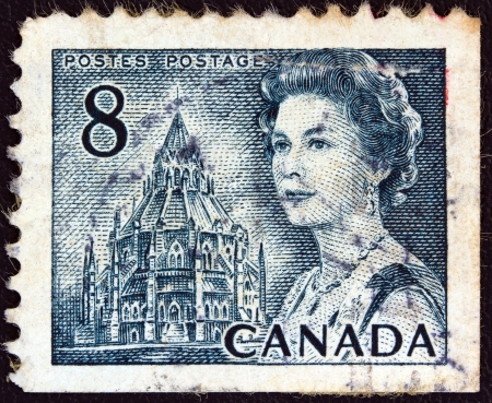 CANADA - CIRCA 1967: A stamp printed in Canada shows a portrait of Queen Elizabeth II and Library of Parliament, circa 1967. のeditorial素材