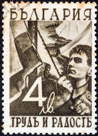 BULGARIA - CIRCA 1942: A stamp printed in Bulgaria from the "Work and Joy" issue shows a young man hoisting the flag, circa 1942. のeditorial素材