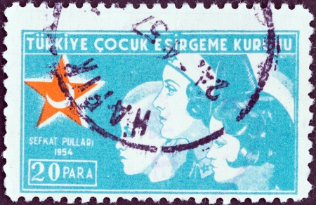 TURKEY - CIRCA 1954: A stamp printed in Turkey from the \"child welfare\" issue shows a nurse with two children, circa 1954. のeditorial素材