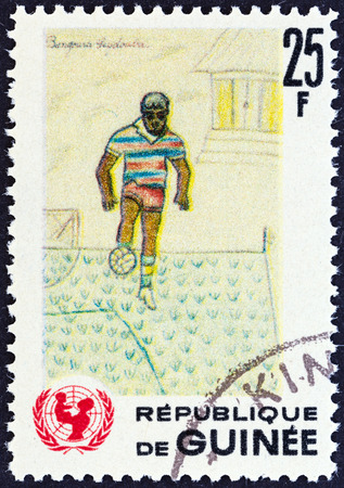 GUINEA - CIRCA 1966  A stamp printed in Guinea from the  The 20th Anniversary of UNICEF   issue shows footballer  children drawing , circa 1966 のeditorial素材