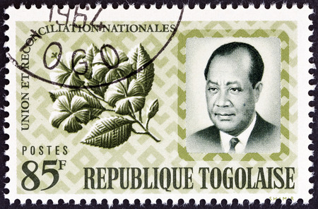 TOGO - CIRCA 1964  A stamp printed in Togo from the  National Union and Reconciliation   issue shows President Nicolas Grunitzky and Hibiscus rosasinensis, circa 1964  のeditorial素材