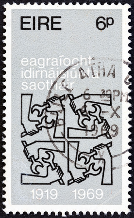 IRELAND - CIRCA 1969: A stamp printed in Ireland issued for the 50th anniversary of International Labor Organization shows Quadruple I.L.O. Emblems, circa 1969.のeditorial素材