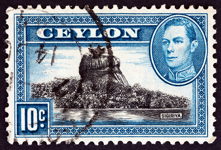 CEYLON - CIRCA 1938: A stamp printed in Ceylon shows Sigiriya (Lion Rock) and King George VI, circa 1938.のeditorial素材