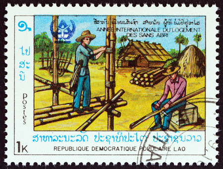 LAOS  CIRCA 1987: A stamp printed in Laos from the "International Year of Shelter for the Homeless " issue shows building bamboo house circa 1987.のeditorial素材