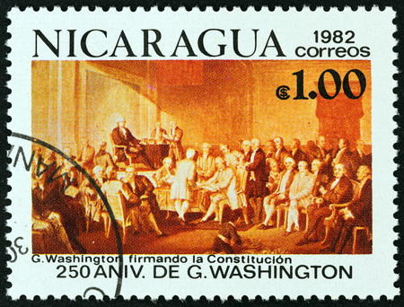 NICARAGUA - CIRCA 1982: A stamp printed in Nicaragua from the "250th anniversary of the birth of George Washington, 1732-1799 " issue shows Washington signing the Constitution, circa 1982.のeditorial素材