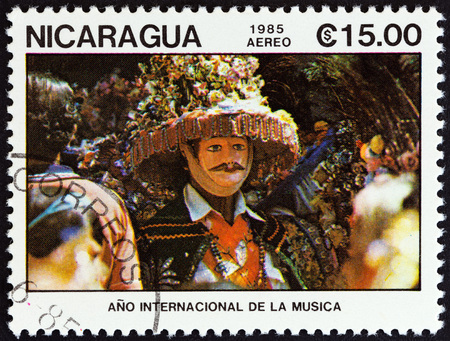 NICARAGUA - CIRCA 1985: A stamp printed in Nicaragua from the "International Music Year " issue shows masked dancer in brimmed hat, circa 1985.のeditorial素材