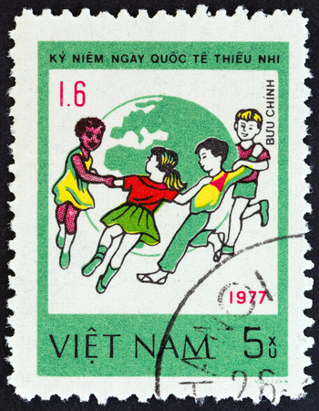 VIETNAM - CIRCA 1980: A stamp printed in Vietnam from the "International Children's Day " issue shows Children dancing around Globe, circa 1980.のeditorial素材