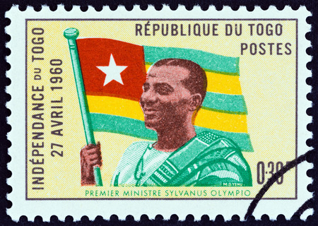 TOGO - CIRCA 1960: A stamp printed in Togo from the "Independence Commemoration" issue shows Prime Minister Sylvanus Olympio and Flag, circa 1960.のeditorial素材