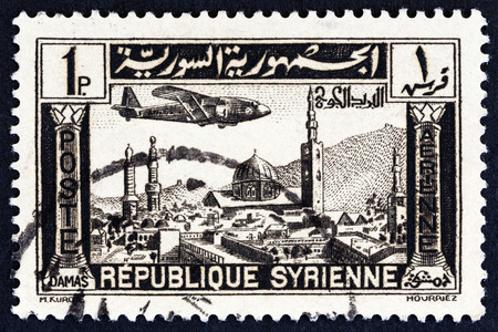 SYRIA - CIRCA 1937: A stamp printed in Syria shows airplane over Damascus, circa 1937.のeditorial素材
