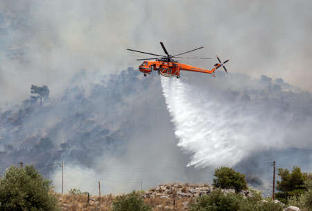 Athens, Greece, June 4, 2022: A firefighting Erickson S-64 Aircrane helicopter operates in Hymettus mount wildfire near Glyfada suburb of Athens.のeditorial素材