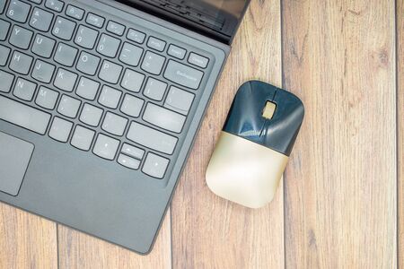 Computer keyboard and mouse on wooden table