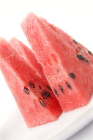 	Slices of watermelon portion in plate close up isolated over white bacgroundの写真素材