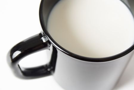 Black cup filled with milk top angle view isolated on white backgroundの写真素材