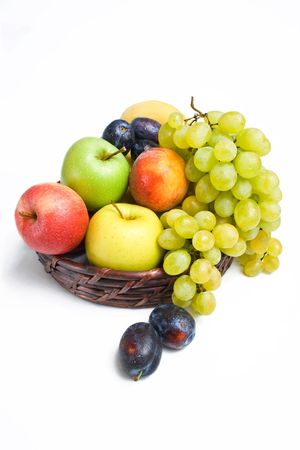 	 Ripe fruits placed in a wicker basket isolated on white backgroundの写真素材