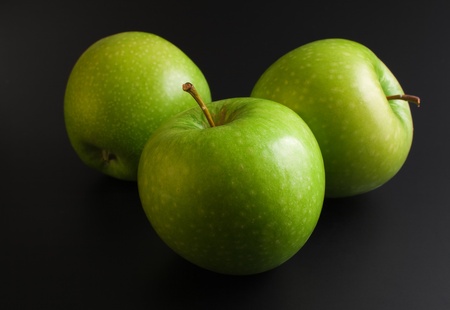 Apples. Three fresh ripe green apples close up arranged on dark background の写真素材
