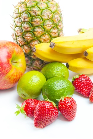 Fruits. Arrangement of various fresh ripe fruits: pineapple, bananas, apple, limes and strawberries closeup  isolated on white backgroundの写真素材
