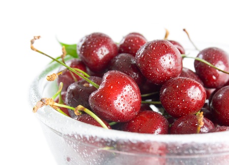 Cherries. Fresh ripe cherries in a class bowl close-up isolated on white background.の写真素材