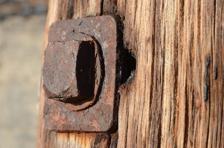 old wooden pillar with rusty boltの写真素材