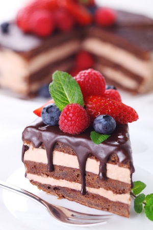 Piece of chocolate cake with icing and fresh berry の写真素材