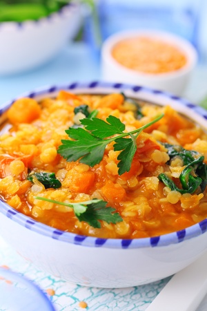 Soup with vegetables, orange lentils and spinach