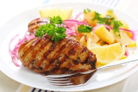 Grilled chicken breast with warm corn and potato saladの写真素材