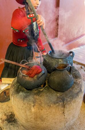 Local village women making colorful handmade textiles at textile site in Chinchero, Peru.の写真素材