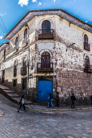 Bright blue door and wood carved balconies in elegant decay in Cusco, Peru.のeditorial素材