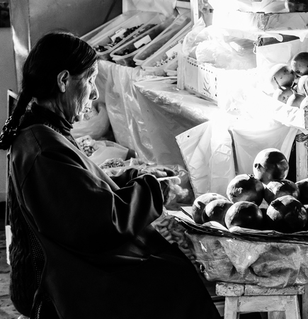 Elderly woman working on preparing produce for sale at the San Pedro market in Cusco, Peru.のeditorial素材