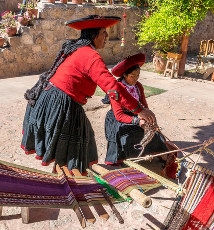 Local village women making colorful handmade textiles at textile site in Chinchero, Peru.のeditorial素材