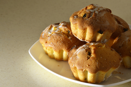 Fresh muffins with raisins on a white plate.の写真素材