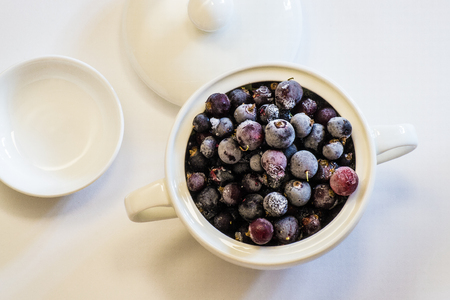 Frozen berries, black currants, in a porcelain dish. view from above. macroの写真素材