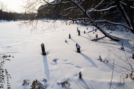 The frozen river in the winter. The snow covers the ice. The river is completely frozenの写真素材