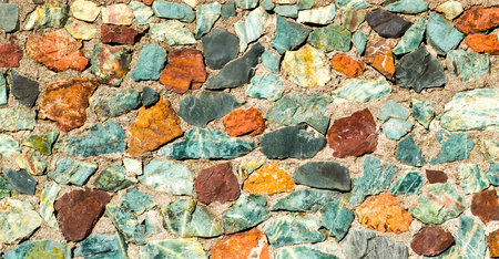 Background texture stone wall of multi-colored stonesの写真素材