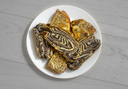 Home roll with poppy and sweets with nuts on a black and white background top viewの写真素材