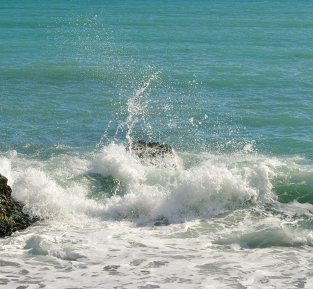 Big waves breaking on the shore with sea foam