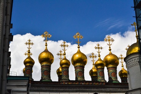 Golden Orthodox crosses and domes of the Church of the Nativity (Verkhospasskiy Sobor) at Kremlin, Moscow with blue skyの写真素材